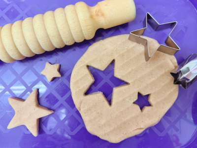 homemade playdough with stars cut out on a purple background